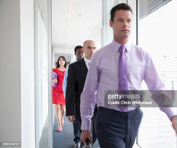 business people walking down corridor - hinterher bewegen stock-fotos und bilder