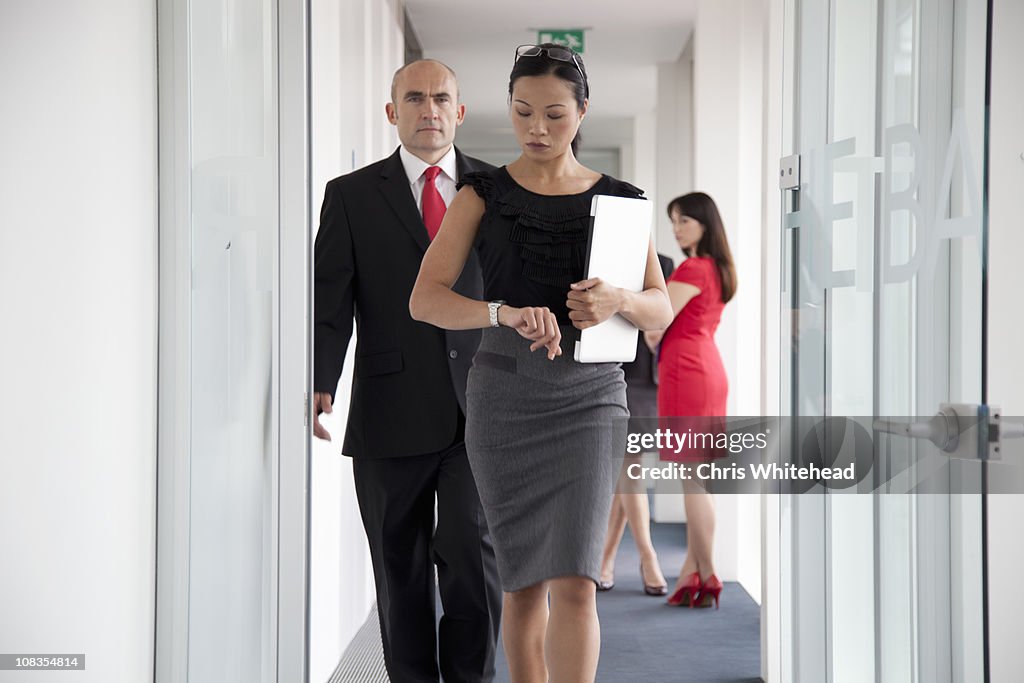 Businesspeople walking down corridor