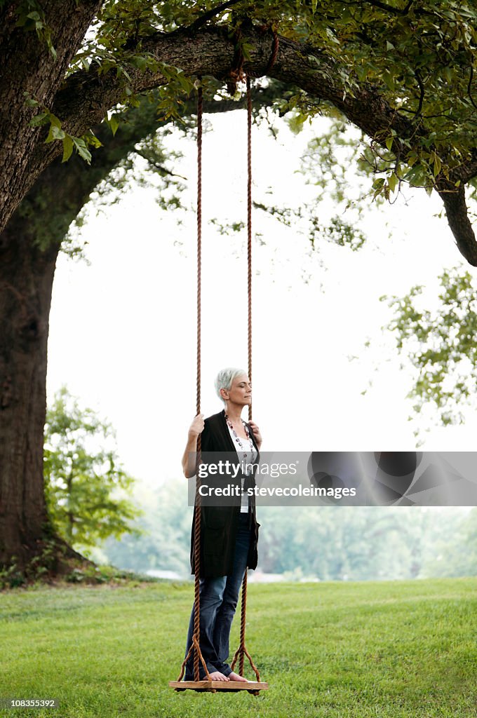 Senior Woman Standing on a Swing