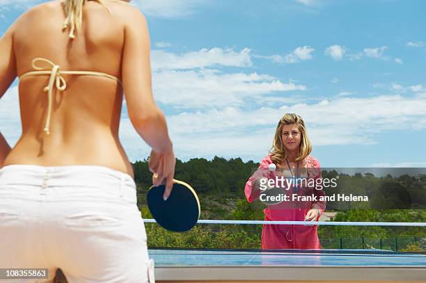 two women playing table tennis outdoors - women's table tennis stockfoto's en -beelden