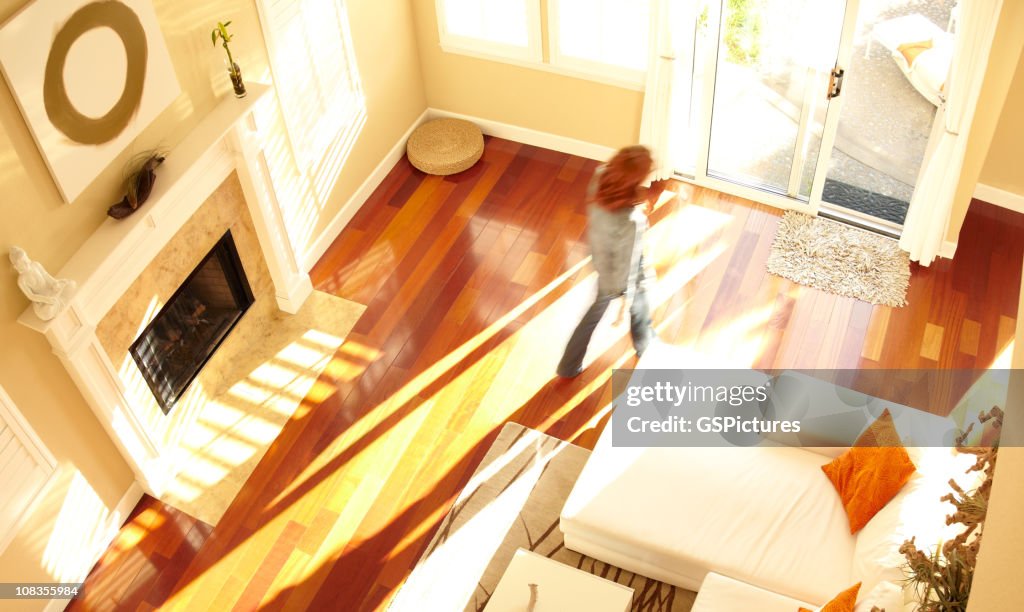 Verschwommene Frau zu Fuß durch moderne Wohnzimmer von oben