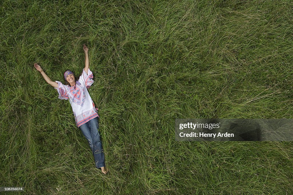 Hippy female relaxing in field