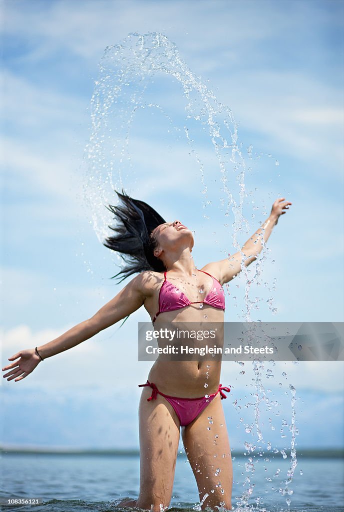 Woman splashing water at the beach