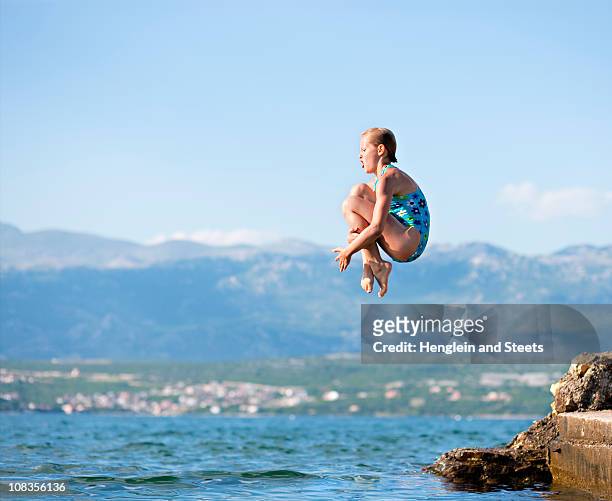 girl jumping into water - cannonball diving stock pictures, royalty-free photos & images