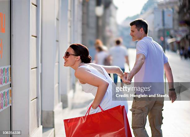 young couple shopping - man and woman holding hands profile stockfoto's en -beelden