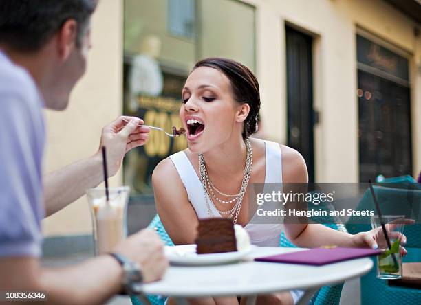 young couple sitting in outdoor caf - couple chocolate stock-fotos und bilder