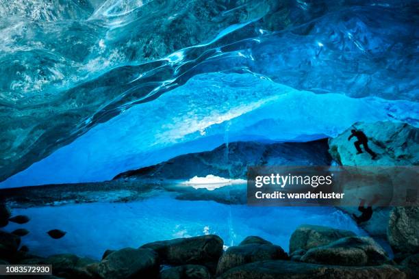 man explores a blue ice cave in norway - jostedalsbreen stock pictures, royalty-free photos & images