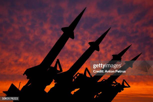 four rockets of anti-aircraft missile system are directed upwards against the background of sunset - russia ストックフォトと画像