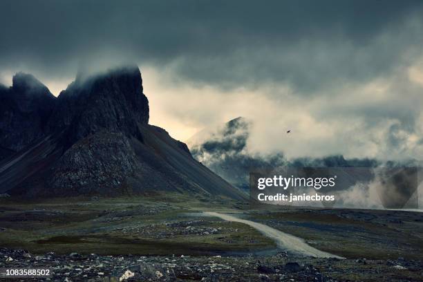 mountainous coastline under cloudy sky. night - iceland landscape stock pictures, royalty-free photos & images