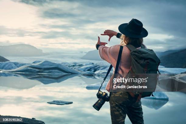 mujer fotógrafa en la laguna de glaciar. puesta de sol - fotografar fotografías e imágenes de stock