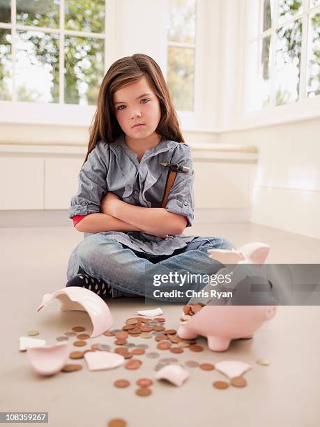 frustrated girl sitting with broken piggy bank - small child sitting on floor stockfoto's en -beelden