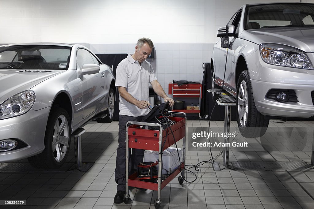 Mechanic looking at computer in auto repair shop