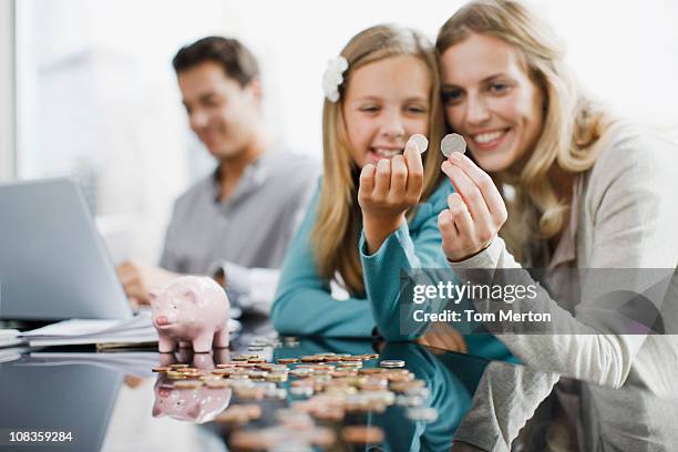 mother and daughter comparing coins - couple counting money stock pictures, royalty-free photos & images