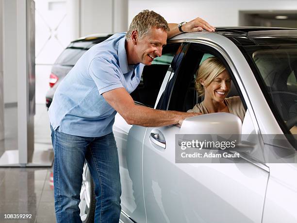 couple looking at new car in showroom - opel celebrates launch of new adam car stockfoto's en -beelden