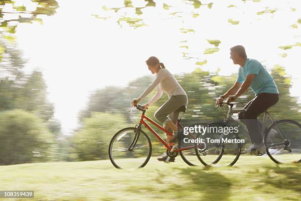 couple riding bicycles together - tom hale stock pictures, royalty-free photos & images