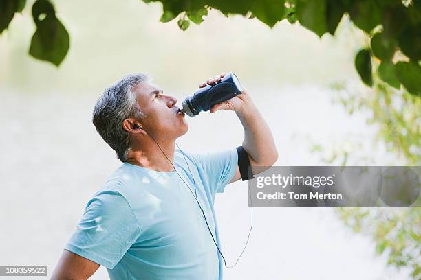 man drinking water after exercise - running man profile stock pictures, royalty-free photos & images