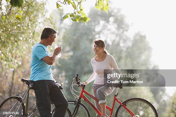 pareja con bicicletas de agua potable - standing water fotografías e imágenes de stock