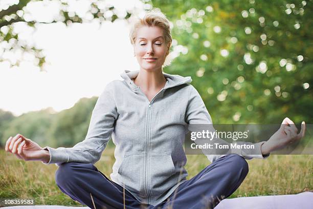 tranquil woman practicing yoga - exercise routine stock pictures, royalty-free photos & images