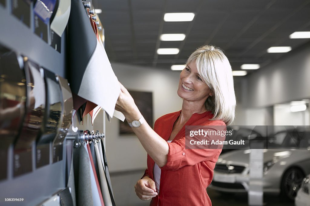 Customer looking at fabric samples in automobile showroom