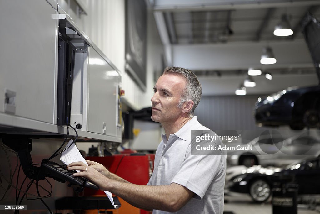 Mechanic using computer in auto repair shop