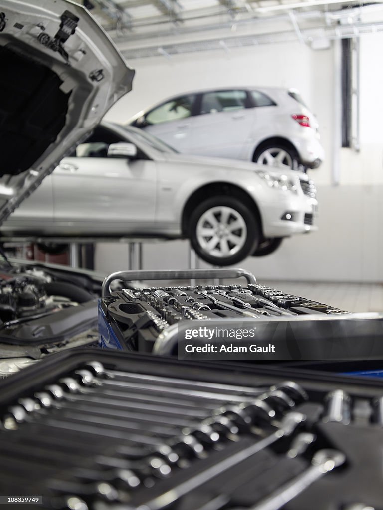 Tools and car engine in auto repair shop