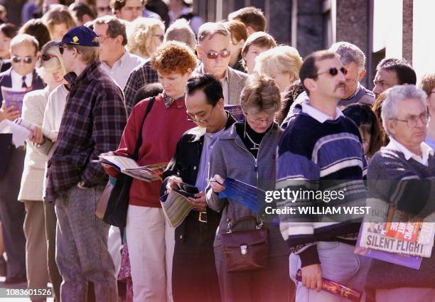 Thousands of people read their ticketing brochures as they queue up for a new release of tickets to the upcoming Sydney 2000 Olympics in Sydney 06...