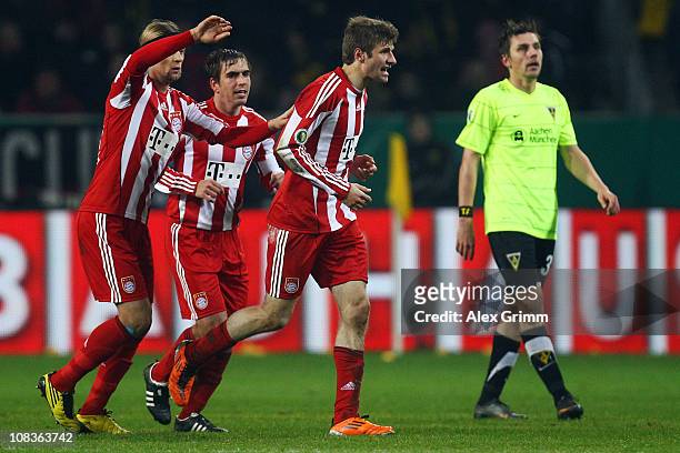 Timo Achenbachen of Aachen reacts as Thomas Mueller of Muenchen celebrates his team's third goal with team mates Philipp Lahm and Anatoliy Tymoshchuk...