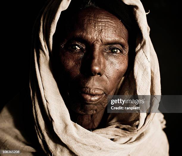 african woman in a headscarf - isolated on black - starving woman stock pictures, royalty-free photos & images
