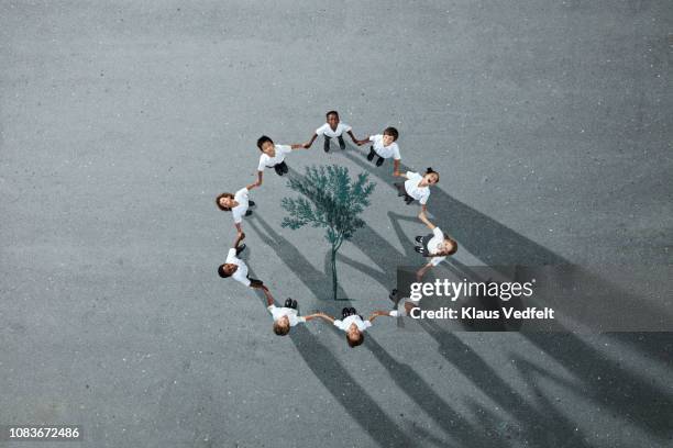 school children in uniforms standing in circle & holding hands - portrait team natürlich stock-fotos und bilder