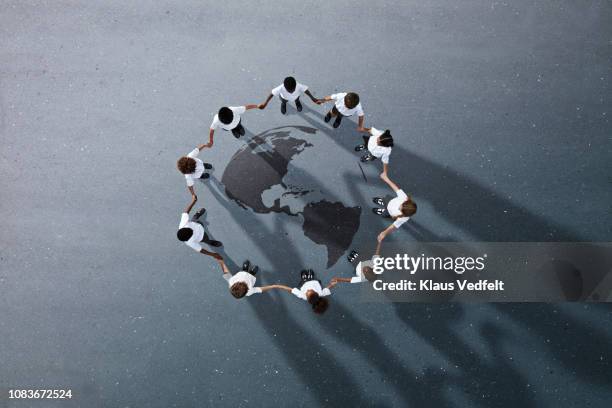 school children in uniforms standing in circle & holding hands - dedicación fotografías e imágenes de stock