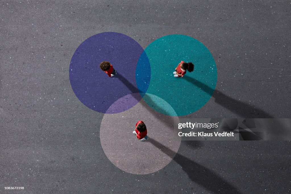 School children in uniforms standing on painted Venn Diagrams