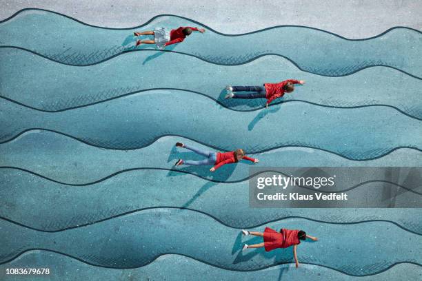children swimming in imaginary painted waves - allongé sur le devant photos et images de collection