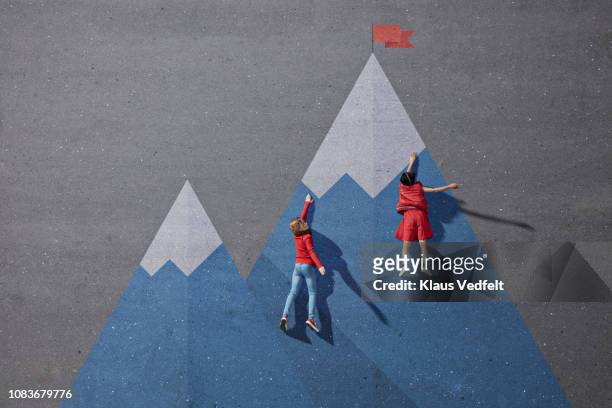 children climbing painted imaginary mountain - wettbewerb konzepte stock-fotos und bilder