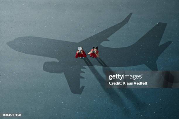 boy & girl standing on shadow of airplane with cameras and looking up - art from the shadows stock pictures, royalty-free photos & images