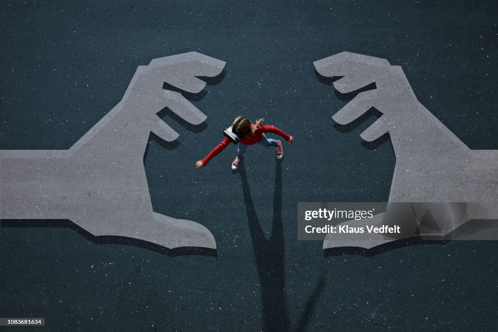 Girl wearing VR goggles walking on background with painted hands