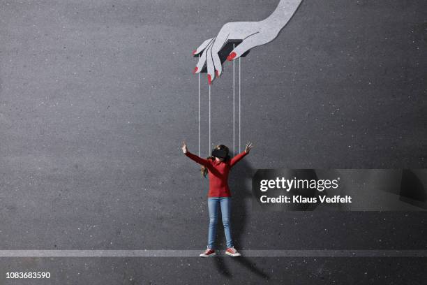 girl wearing vr goggles laying on background with imaginary painted puppeteer hand - mani fili foto e immagini stock