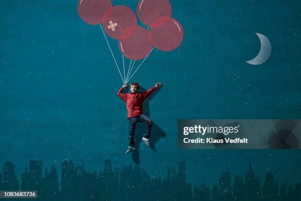 boy wearing vr goggles holding painted imaginary balloons flying above skyline - flying goggles imagens e fotografias de stock