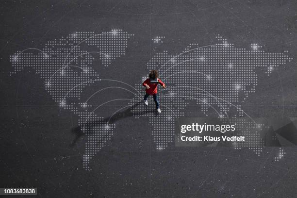 boy wearing vr goggles walking on painted imaginary world map - people technology connected overhead foto e immagini stock