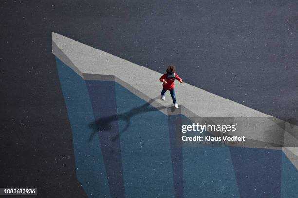 boy wearing vr goggles walking on the edge of painted imaginary cliff - illusion stock-fotos und bilder