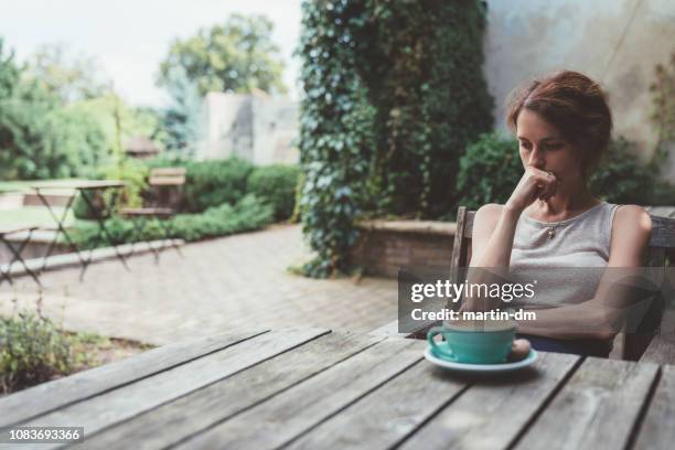 depressive frau trinkt kaffee auf der veranda - relationship difficulties stock-fotos und bilder