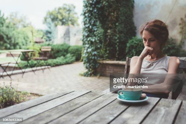 deprimerad kvinna dricker kaffe på verandan - förödmjukelse bildbanksfoton och bilder