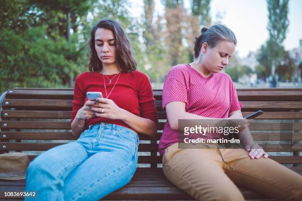 couple with problems texting outside and not talking to each other - sad gay person stock pictures, royalty-free photos & images