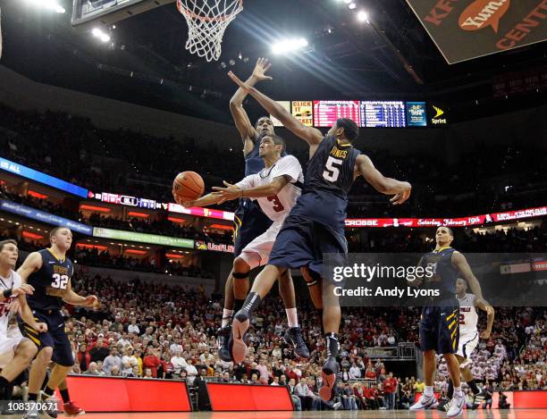 Peyton Siva of the Louisville Cardinals shoots the game winning shot while defended by John Flowers and Kevin Jones of the West Virginia Mountaineers...