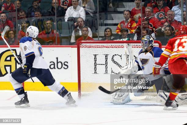Erik Johnson shoots the puck into his own goal as Ty Conklin of the St. Louis Blues reacts during the first period against the Calgary Flames on...