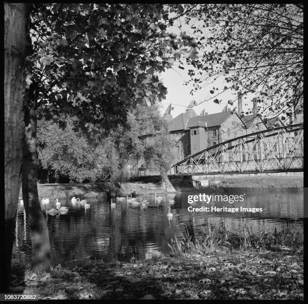 Malthouses, Bass Old Brewery, Friars' Walk, Burton-on-Trent, Staffordshire, 1960-1974. Swans on the River Trent beside Andresey Bridge and the...