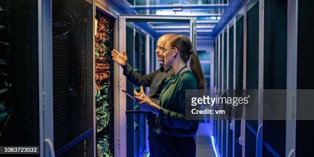 it-techniker, die server-funktion, eine managerin in einem rechenzentrum zu erklären - mainframe stock-fotos und bilder