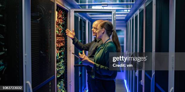 it technician explaining server function to a female manager in a data center - it support server stock pictures, royalty-free photos & images