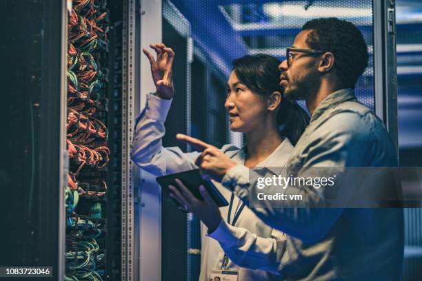 亞洲女性 it 技術員向新手工程師解釋網路連接 - 光纖 個照片及圖片檔