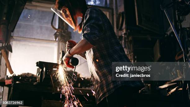frau arbeitet mit winkelschleifer - schmied stock-fotos und bilder