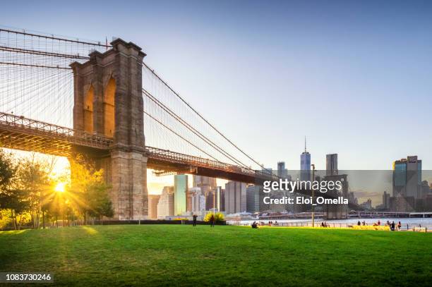 brooklyn bridge und manhattan bei sonnenuntergang. new york city - brooklyn new york stock-fotos und bilder